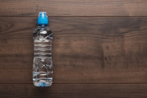 Water bottle with blue lid on wooden table